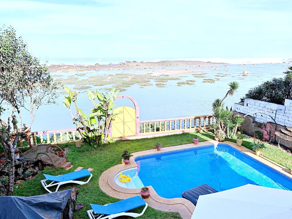 a swimming pool with a view of the ocean at Aux Moules de Harhoura Rabat in El Harhoura