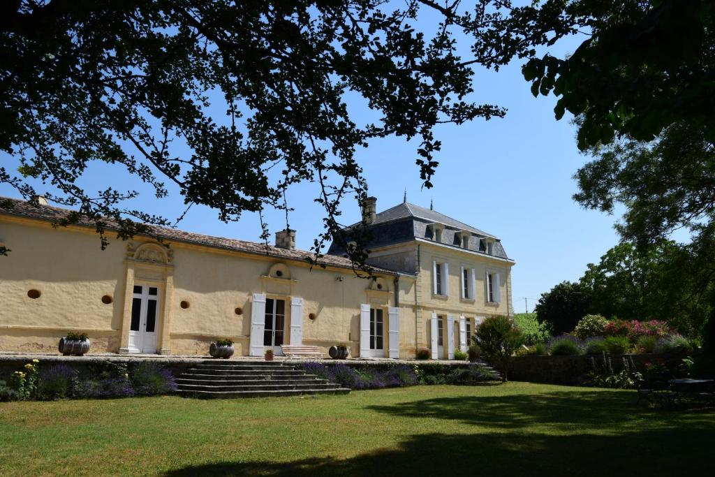 une vieille maison avec une grande cour devant elle dans l'établissement Château Richelieu, à Fronsac