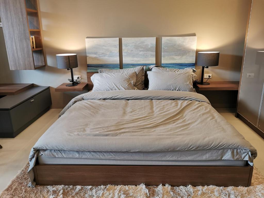 a large bed in a bedroom with two lamps at Escape Condominum E125 in Mae Pim