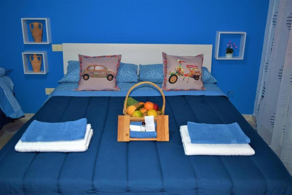 uma cama azul com duas cestas de fruta em Nonna Sicilia B&B em Capri Leone