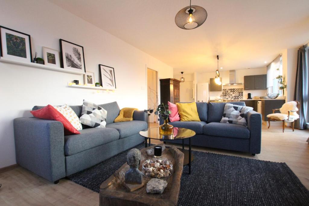 a living room with a blue couch and a table at Colmar City Center - Bright and Large Appartement REMPARTS in Colmar