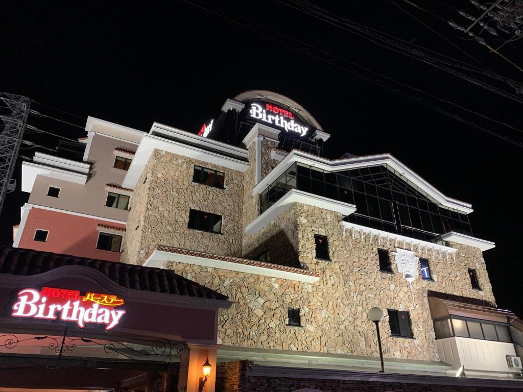 ein Gebäude mit einem Schild darüber in der Unterkunft HOTEL Birthday 楠店 in Toyoyama