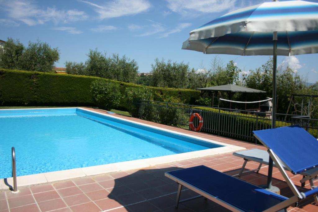 piscina con ombrellone e due sedie e tavolo e ombrellone di CERRETINI a Montepulciano