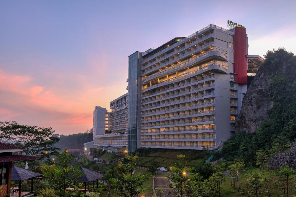 a large building with a mountain in front of it at Le Eminence Puncak Hotel Convention & Resort in Puncak