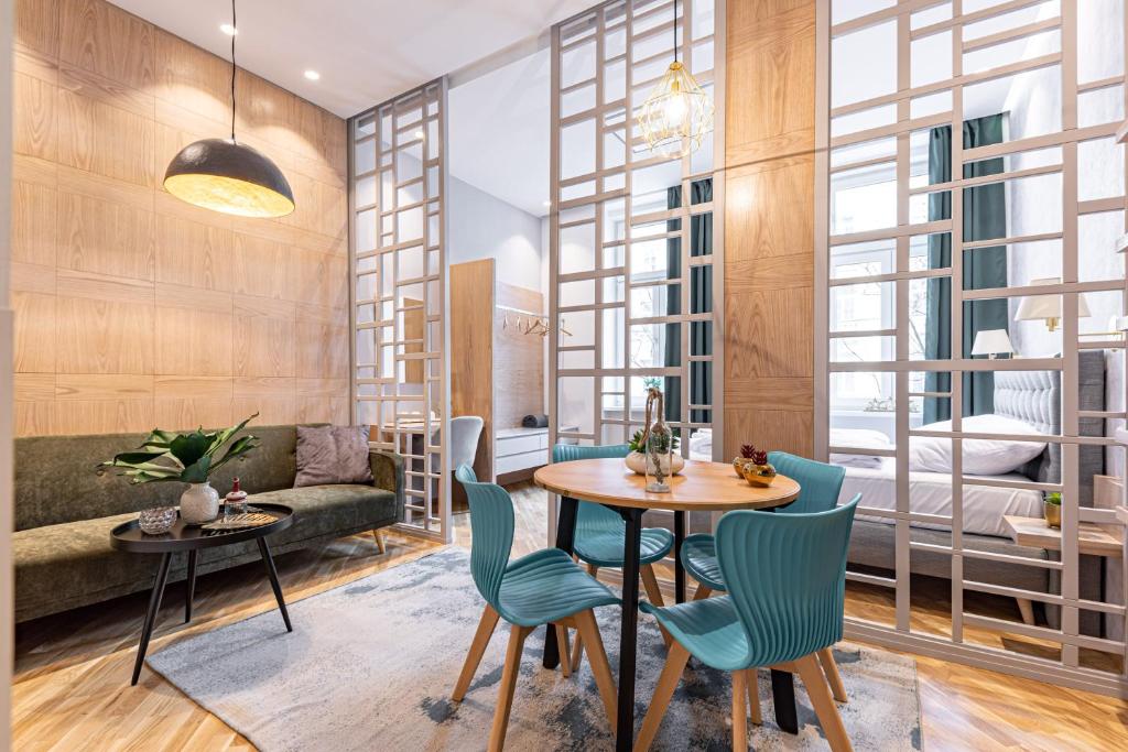 - un salon avec une table, des chaises et un canapé dans l'établissement ZEUS Design Apartments, à Vienne