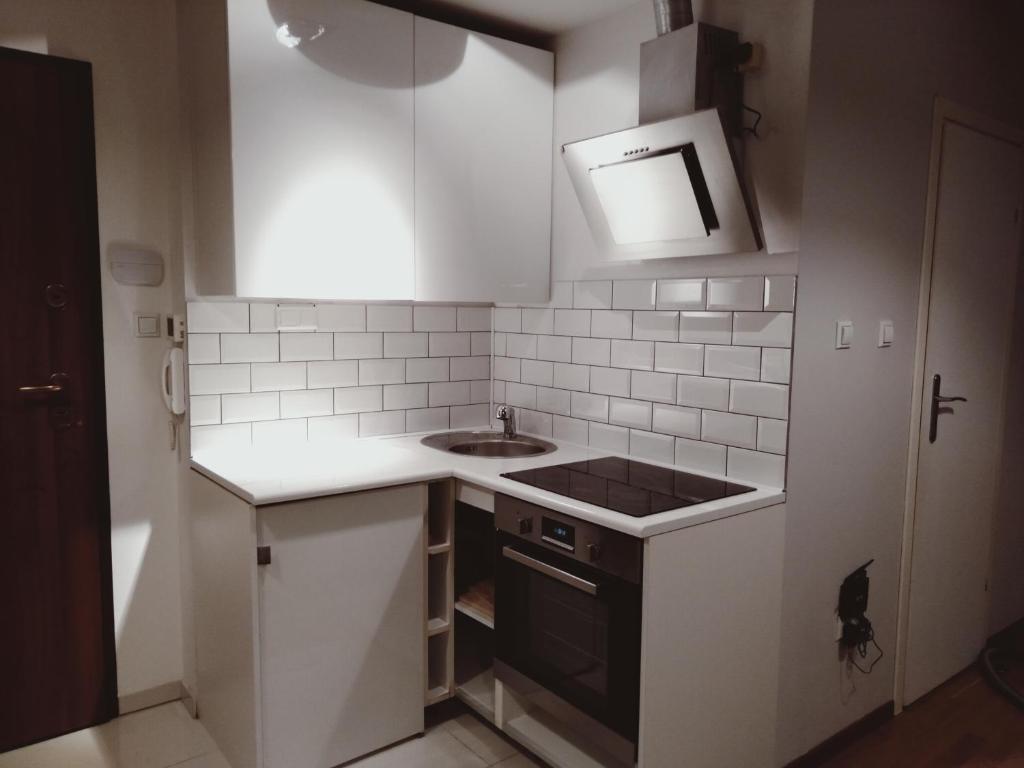 una pequeña cocina con armarios blancos y fregadero en Apartament Kasprowy Jaszczurówka en Zakopane
