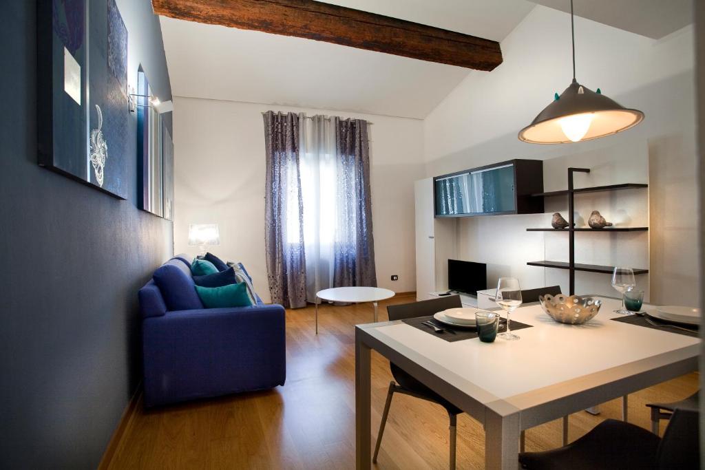 un soggiorno con tavolo e sedia blu di FILARMONICO SUITES a Verona