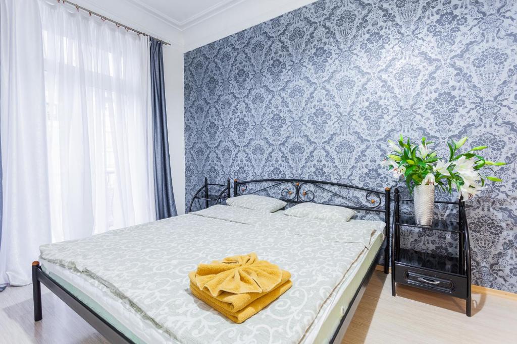 ein Schlafzimmer mit einem Bett mit einer gelben Decke darauf in der Unterkunft Tarasa Shevchenko Boulevard 10 in Kiew