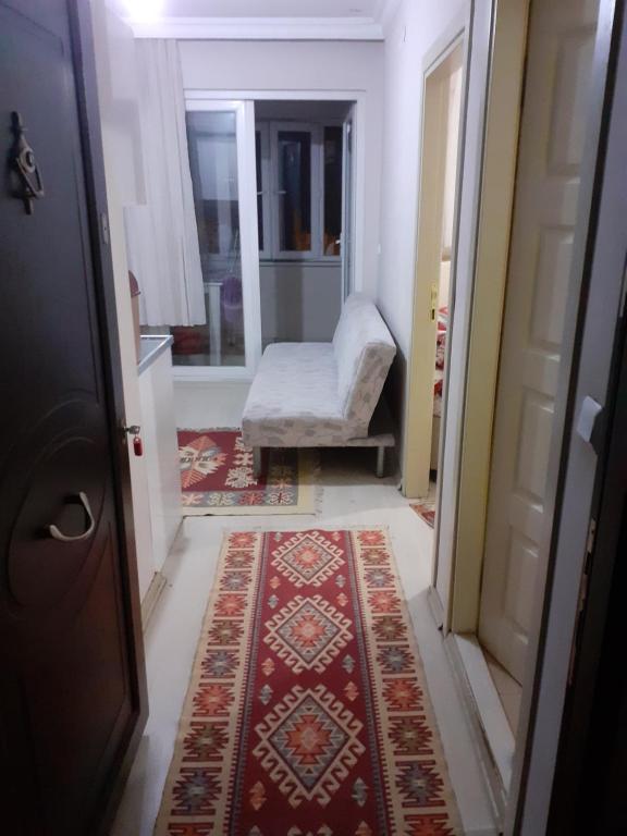 a hallway with a door and a chair and a rug at Safranbolu student hostel woman only in Karabük