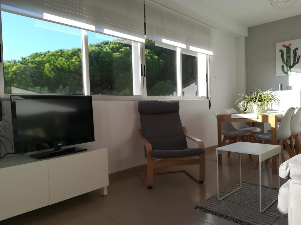 un soggiorno con TV a schermo piatto e sedie di Duna de arenales ad Arenales del Sol