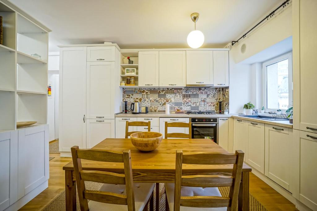 a kitchen with a wooden table and chairs at Visit Bucharest Romana Square Central Apt. - Metro in Bucharest