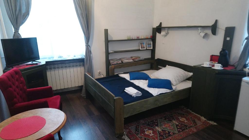 ワルシャワにあるStudio Stare Miastoの小さなベッドルーム(ベッド1台、椅子付)