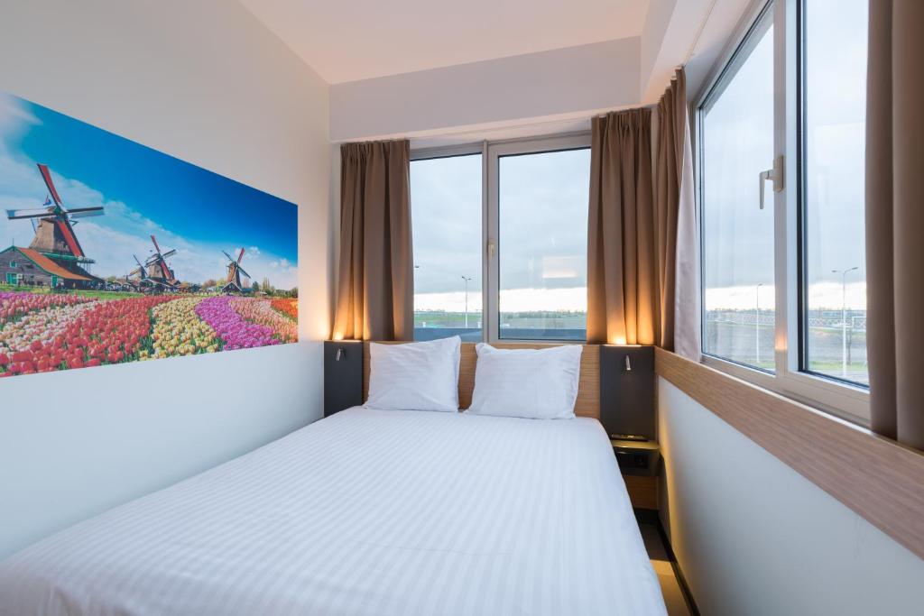 
a hotel room with a bed and a window at Maxhotel Amsterdam Airport Schiphol in Hoofddorp
