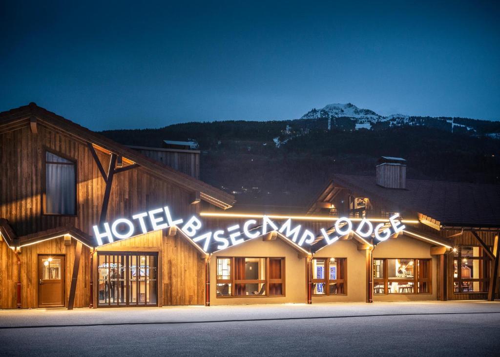 un hotel con un cartello sul lato di un edificio di Hotel Base Camp Lodge - Bourg Saint Maurice a Bourg-Saint-Maurice