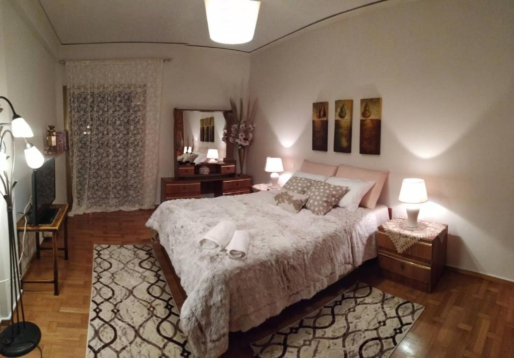 um quarto com uma cama grande com 2 mesas e 2 candeeiros em House Christy em Tríkala