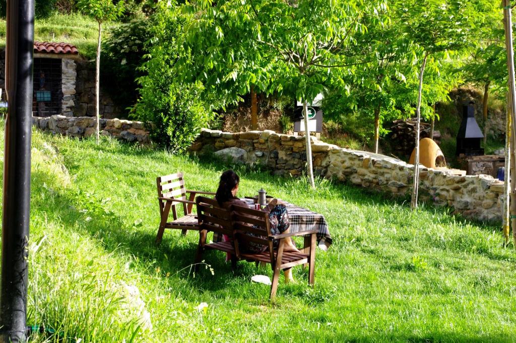 a woman sitting on a bench in the grass at Riojania in Munilla