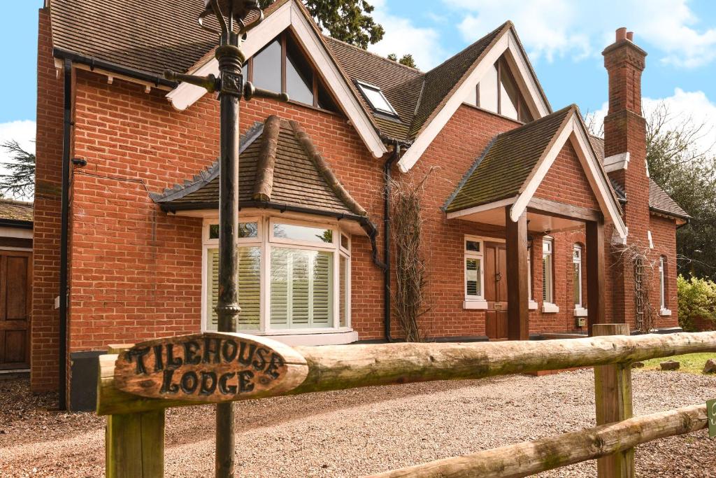 a house with a sign in front of it at Tilehouse lodge in Denham