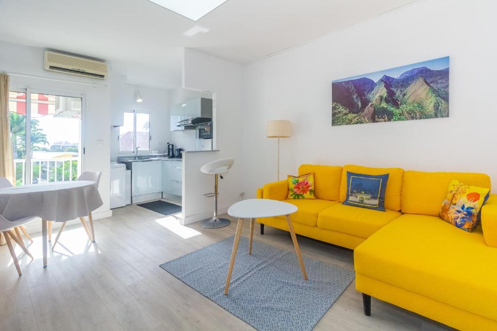 a living room with a yellow couch and a table at Montreuil - joli T2 refait à neuf centre-ville de Saint-Denis in Saint-Denis