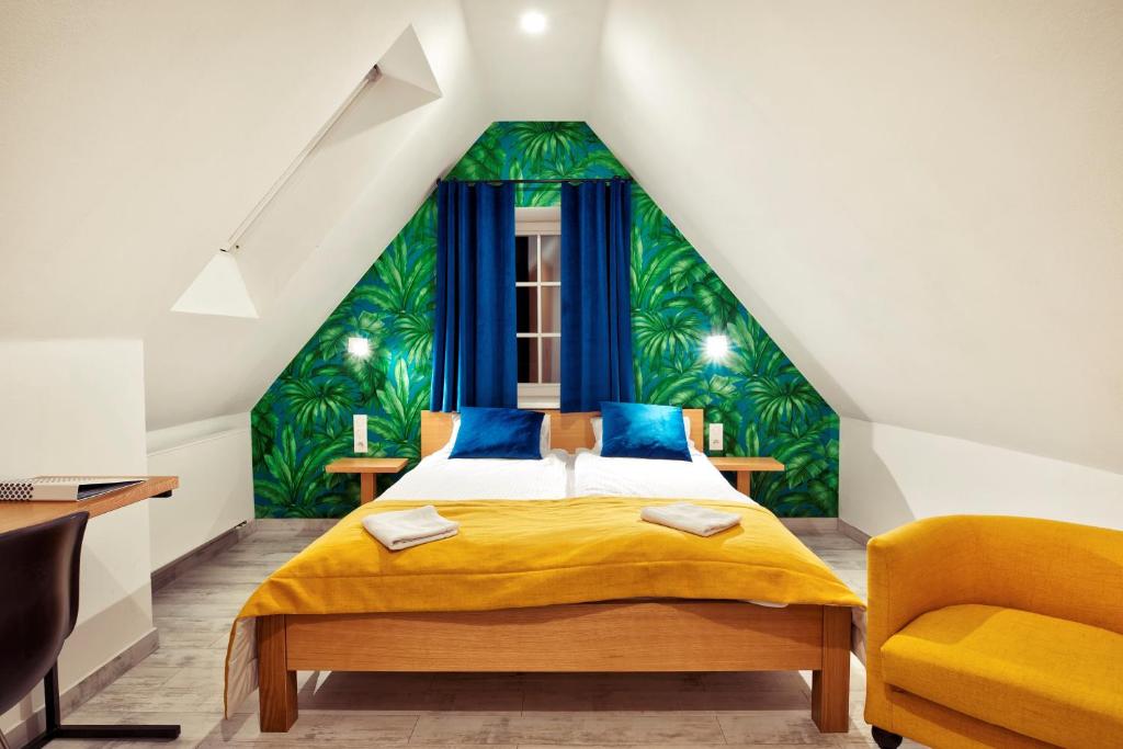 sypialnia z żółtym łóżkiem i zielonym malowidłem ściennym w obiekcie TCZ Woźna w Poznaniu