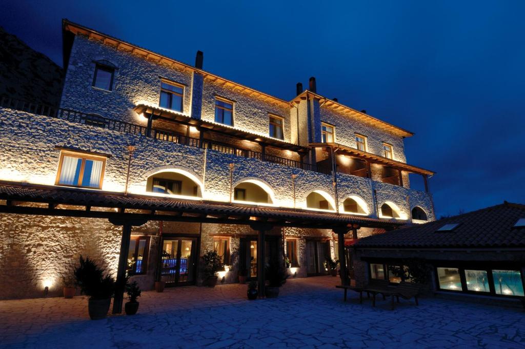 a large building with lights on it at night at Santa Marina Arachova Resort & Spa in Arachova