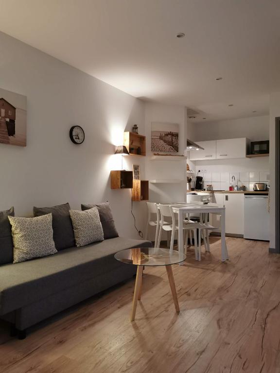un salon avec un canapé et une table dans l'établissement La maisonnette au centre ville, à Lens