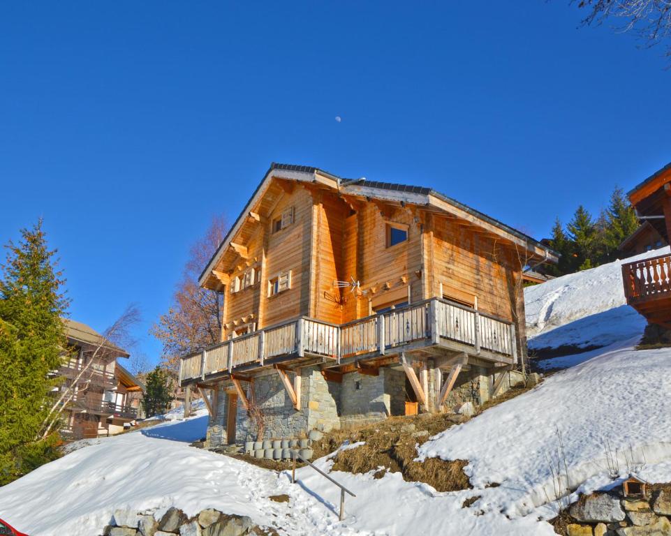 una casa de madera en la nieve en una montaña en Chalet Phoenix, en Montalbert