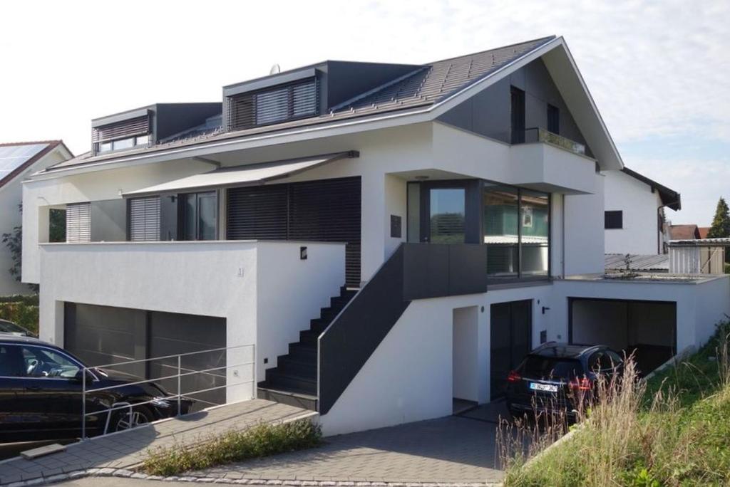 una casa blanca con techo negro en Loft Rebhalde, en Nonnenhorn