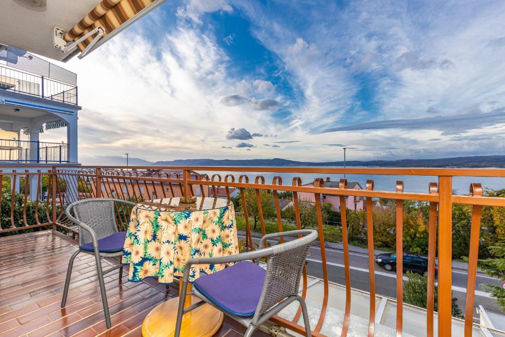 a balcony with chairs and a view of the water at Vacattio apartments in Crikvenica