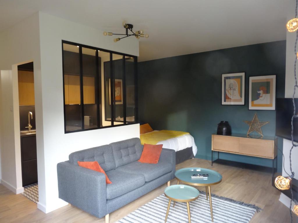 un salon avec un canapé et un lit dans l'établissement La vie est Belle, à Sélestat