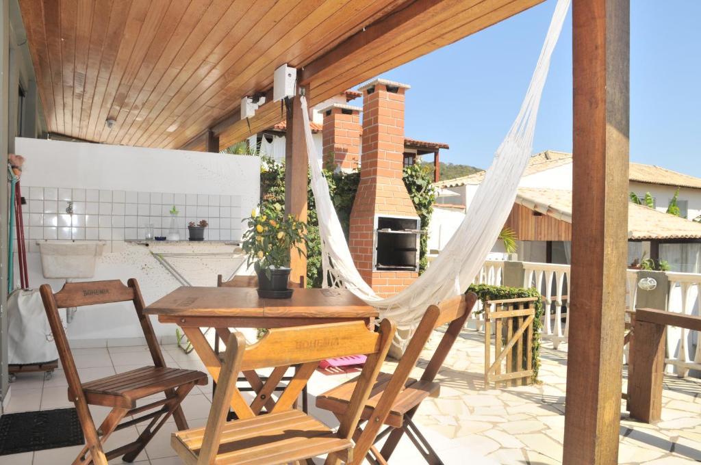 a porch with a hammock and a table and chairs at APARTAMENTO CRISTAL in Búzios