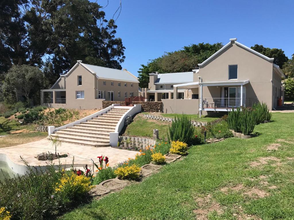 a house with a staircase in a yard at The Suites at Waterryk Eco Guest Farm in Stilbaai
