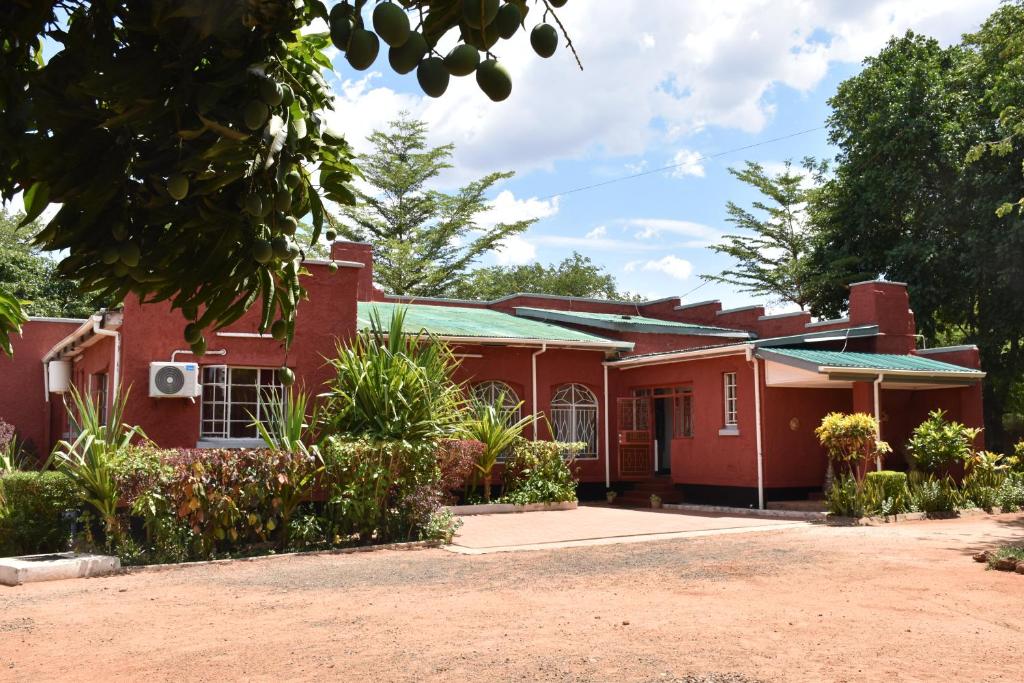 ein rotes Backsteinhaus mit grünem Dach in der Unterkunft Tabonina Bis in Livingstone