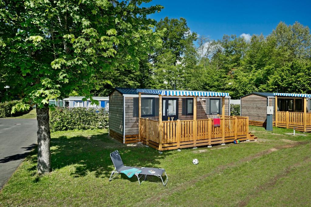 un patio con una casa y una silla delante de ella en KNAUS Campingpark Bad Kissingen en Bad Kissingen