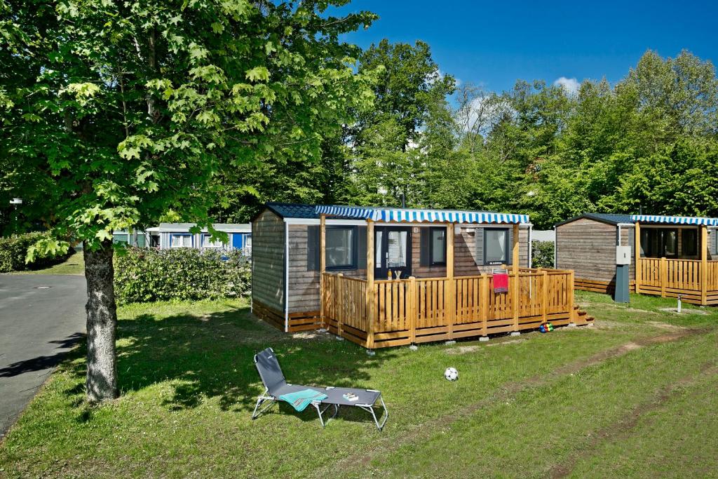 une cour avec une maison et une chaise devant elle dans l'établissement KNAUS Campingpark Bad Kissingen, à Bad Kissingen