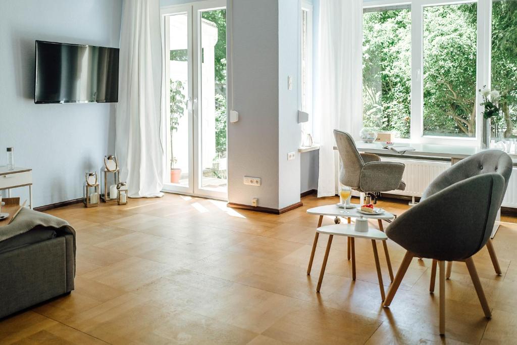 een woonkamer met een bank, stoelen en een tafel bij Doppelzimmer an der TA (Nr. 1) in Hameln