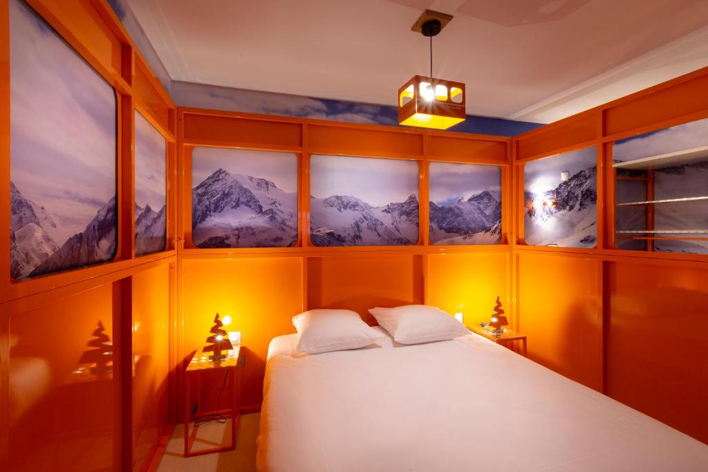 a bedroom with a bed with mountains painted on the walls at Hotel Base Camp Lodge - Bourg Saint Maurice in Bourg-Saint-Maurice