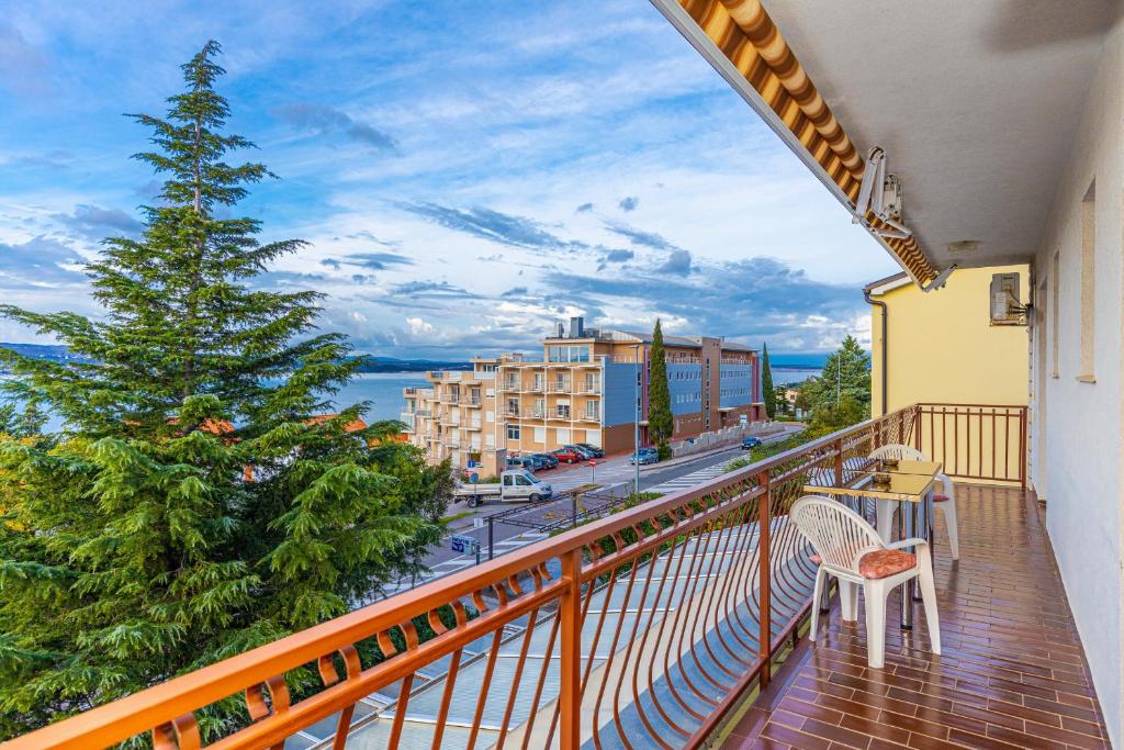 a balcony with a table and a chair and a christmas tree at Vacattio apartment 2 in Crikvenica