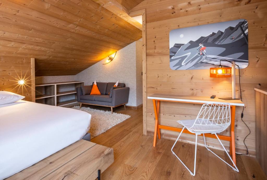 a bedroom with a bed and a desk in a room at Hotel Base Camp Lodge - Bourg Saint Maurice in Bourg-Saint-Maurice