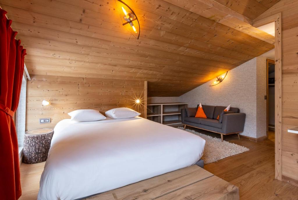 a bedroom with a large white bed in a room at Hotel Base Camp Lodge - Bourg Saint Maurice in Bourg-Saint-Maurice