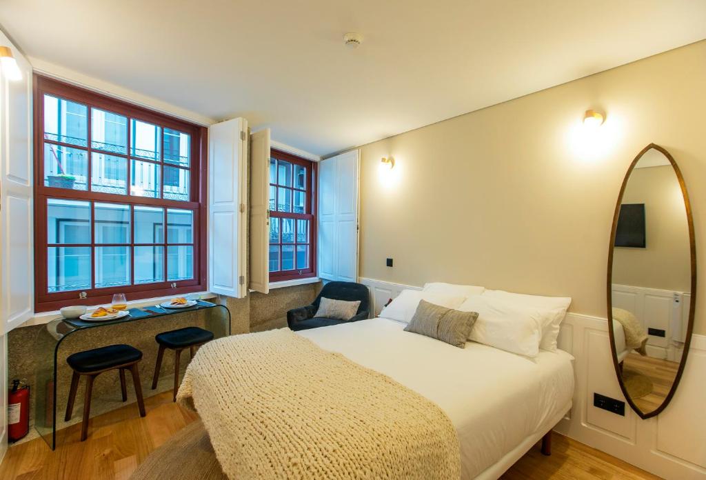 um quarto de hotel com uma cama e um espelho em Charming Studio in Historic Downtown em Porto