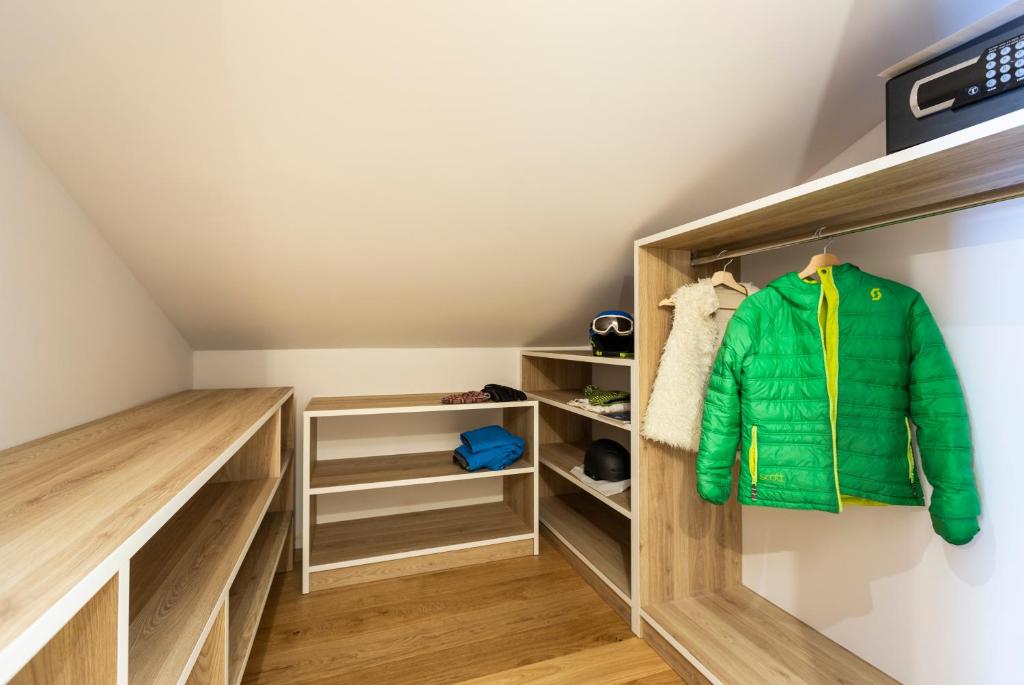 a room with wooden shelves and a green jacket at Hotel Base Camp Lodge - Bourg Saint Maurice in Bourg-Saint-Maurice