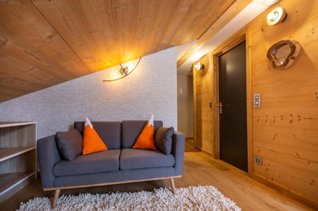 a living room with a blue couch with orange pillows at Hotel Base Camp Lodge - Bourg Saint Maurice in Bourg-Saint-Maurice