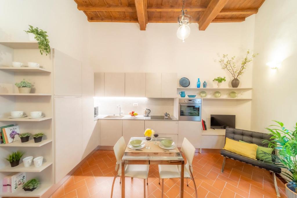eine Küche und ein Wohnzimmer mit einem Tisch und Stühlen in der Unterkunft Little Gem in the city center in Florenz