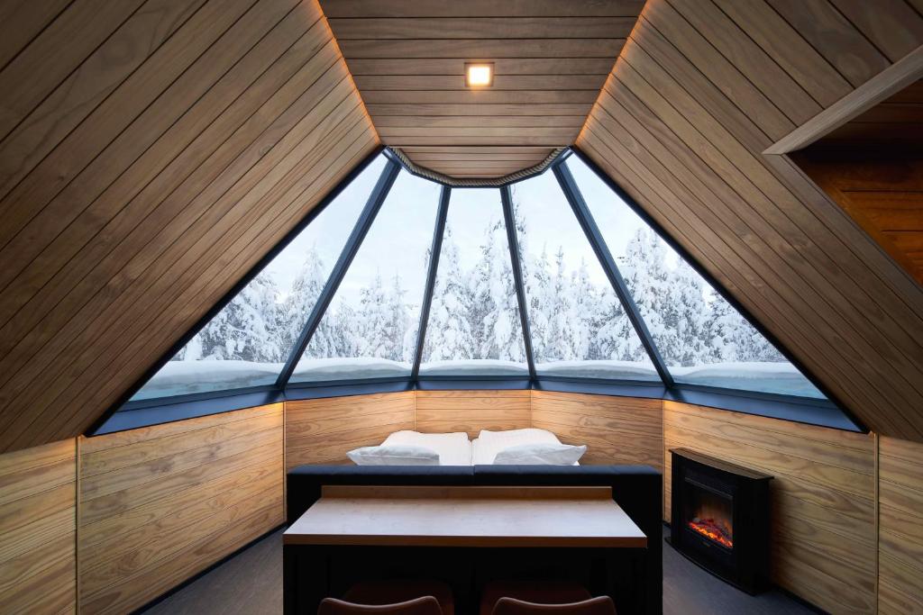 uma grande janela num quarto com uma cama e uma lareira em Northern Lights Village Levi em Levi