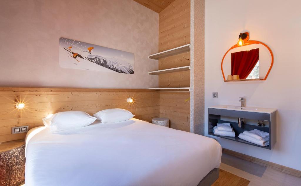 a bedroom with a large white bed and a mirror at Hotel Base Camp Lodge - Bourg Saint Maurice in Bourg-Saint-Maurice