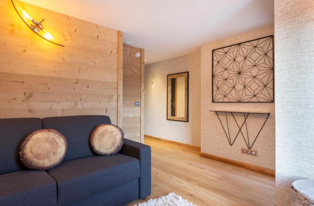 a living room with a blue couch and a wooden wall at Hotel Base Camp Lodge - Bourg Saint Maurice in Bourg-Saint-Maurice