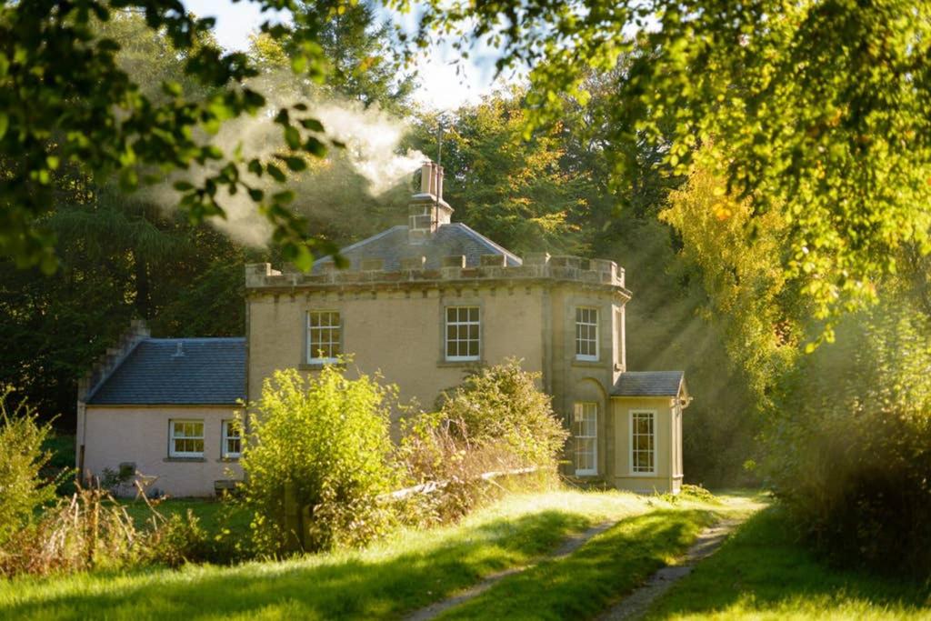 an old house in the middle of a field at Quarry Gardens Lodge in Fochabers