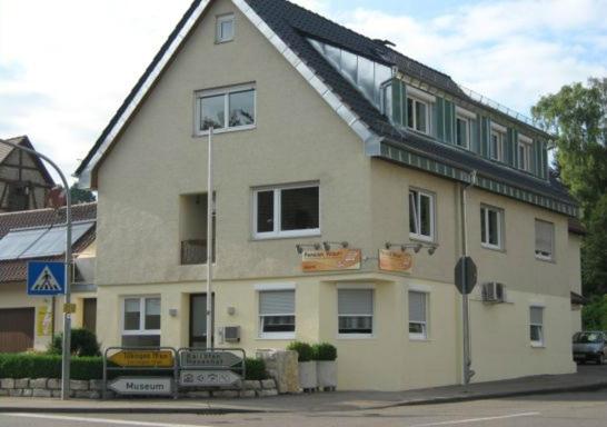 a large house with a roof on a street at Pension Wauri , Ferienwohnung ' SCHWARZWALD ' , Erdgeschoss in Waldenbuch
