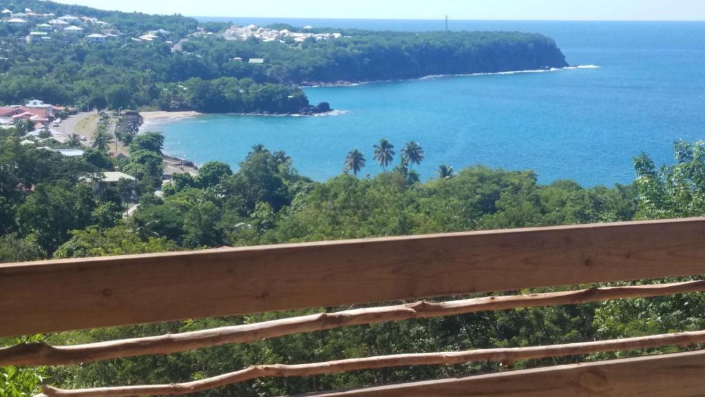 a view of a beach and the ocean from a bench at VILLA KAYOU in Deshaies