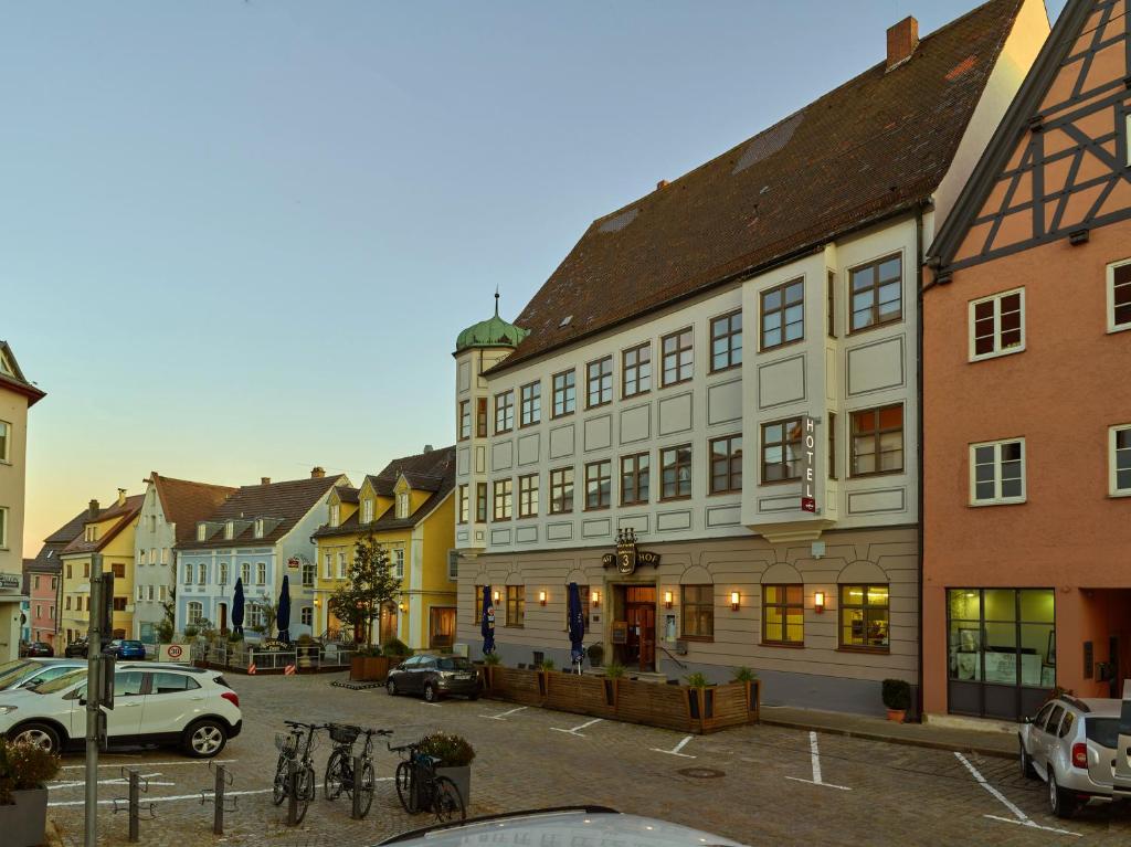 eine Straße in einer Stadt mit Gebäuden und Autos in der Unterkunft Lodner Hotel Drei Mohren in Lauingen